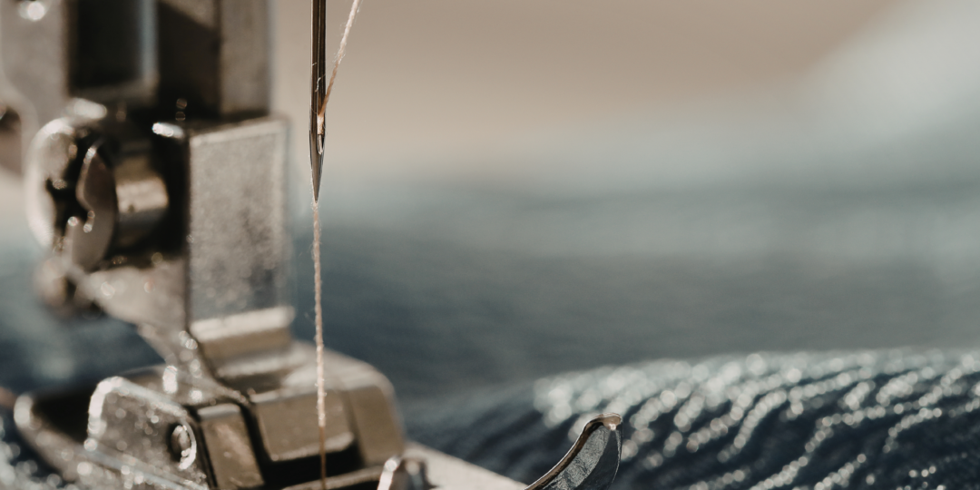 Plan rapproché d’une machine à coudre utilisant un fil pour coudre le tissu