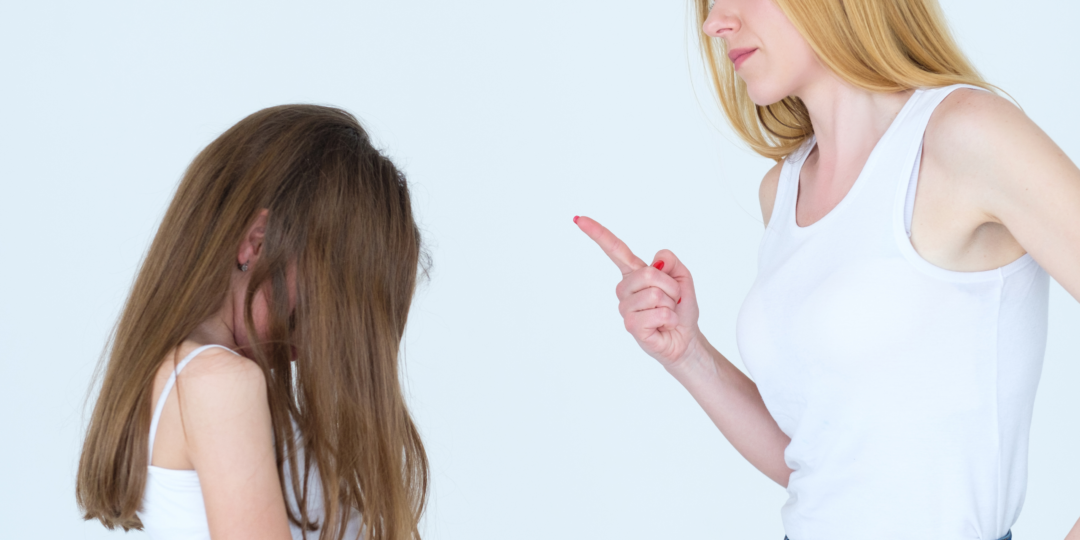 Femme levant le doigt face à sa fille dans un geste d’avertissement