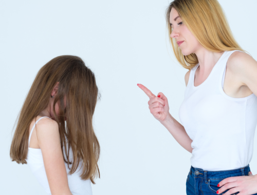 Femme levant le doigt face à sa fille dans un geste d’avertissement