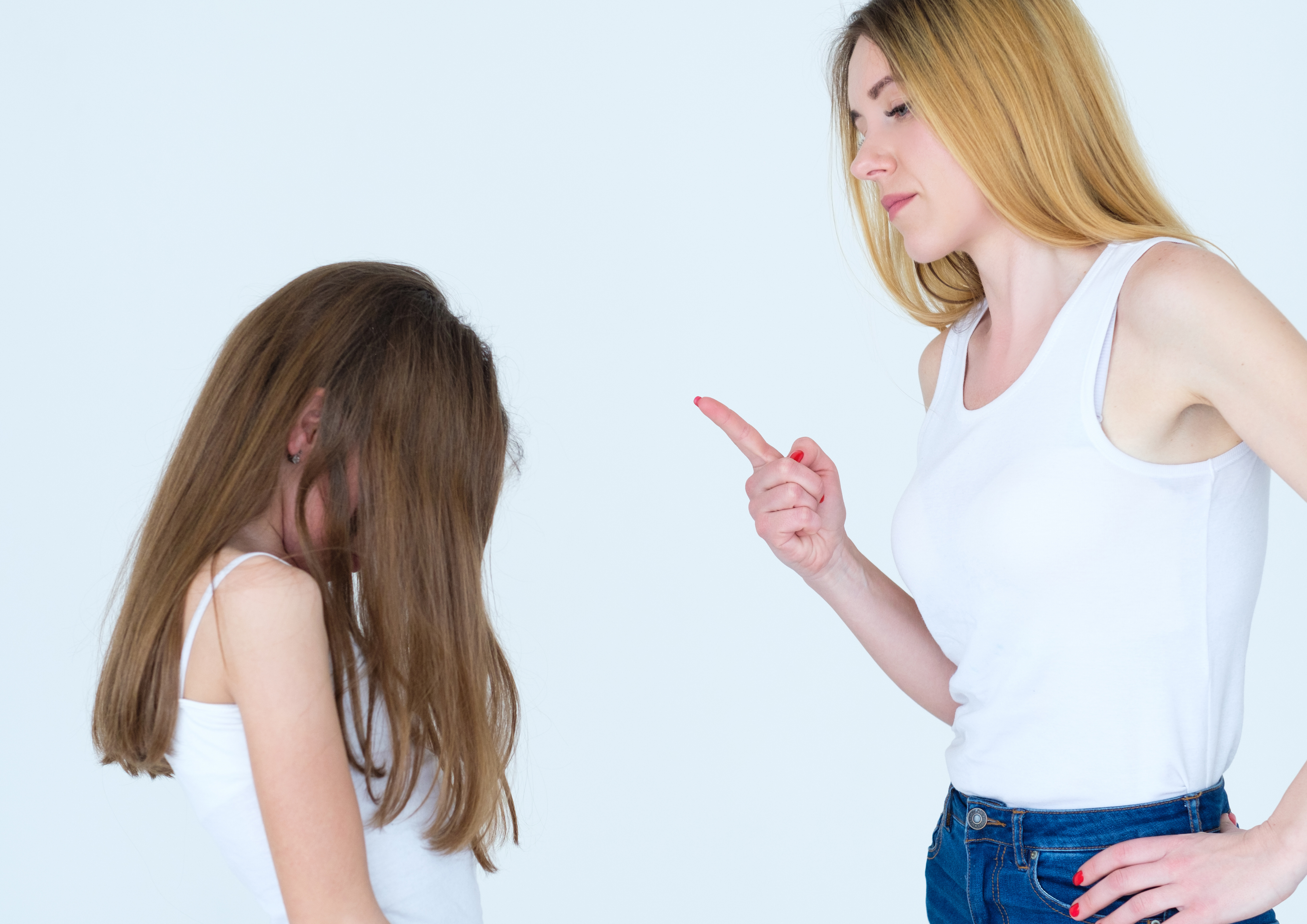 Femme levant le doigt face à sa fille dans un geste d’avertissement