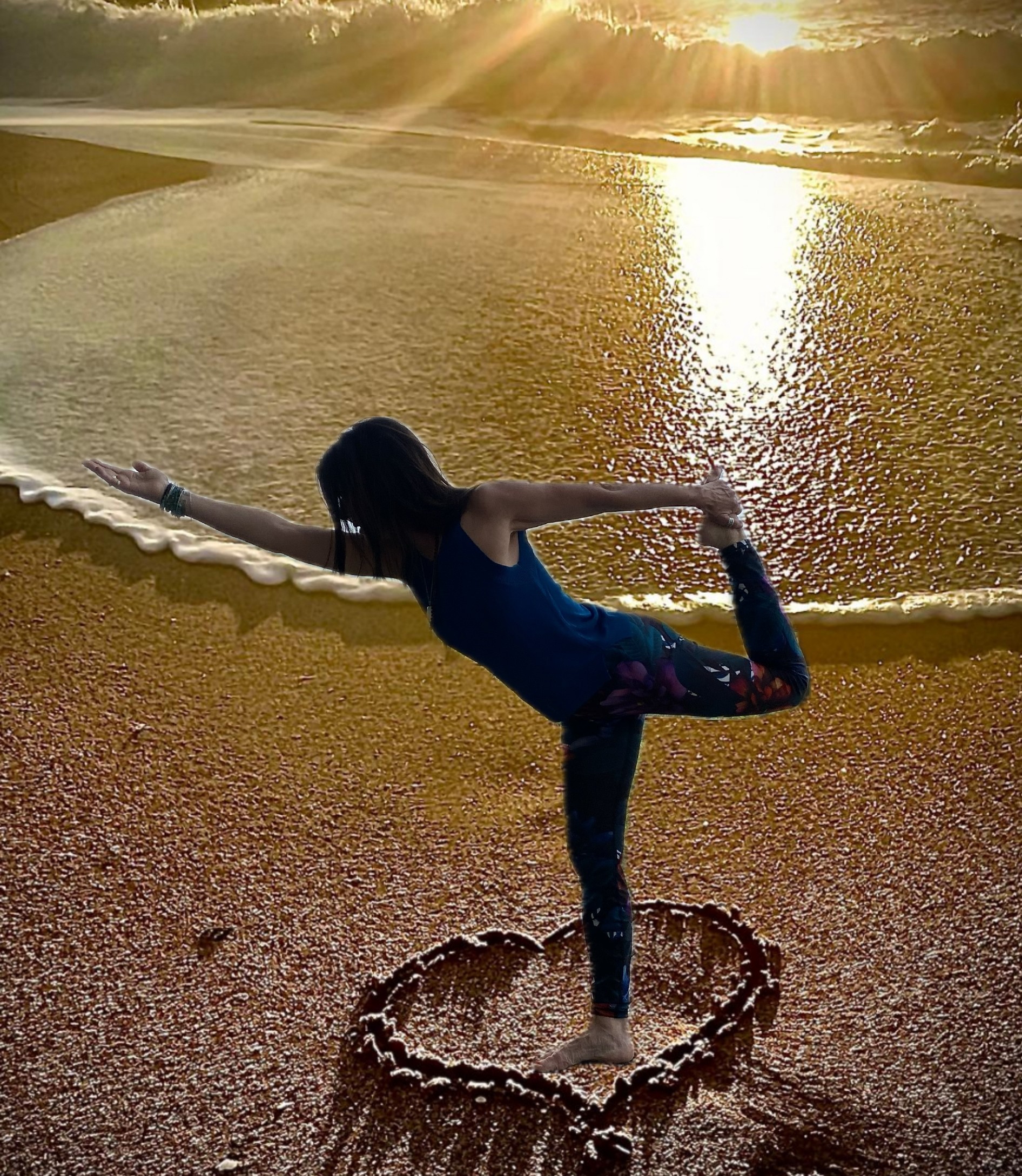 Femme réalisant une posture de yoga sur une plage au coucher du soleil