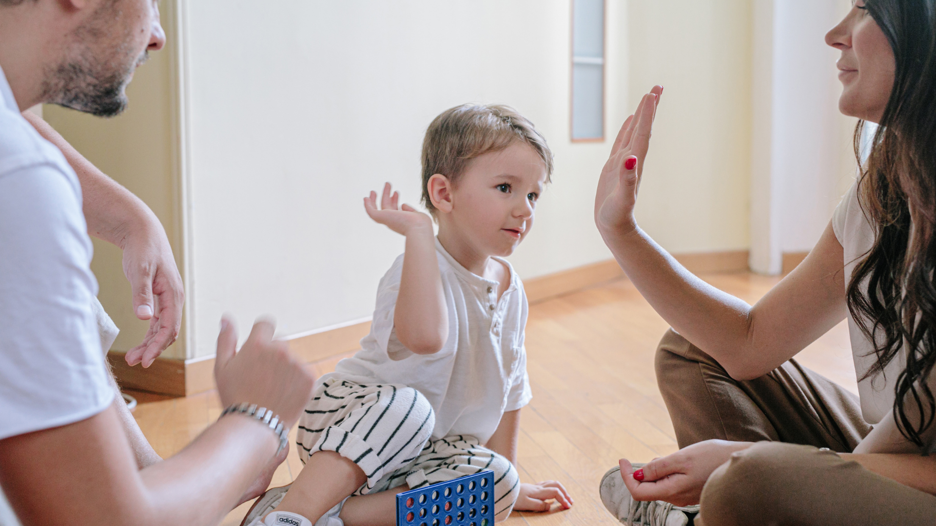 Enfant qui joue avec ses deux parents lors d'un atelier parent et bambin