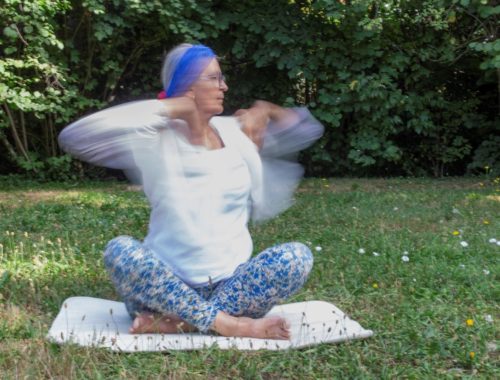 Pratiquante de Yoga Kundalini réalisant un exercice de respiration et de mouvements des bras en plein air pour favoriser l'énergie et le bien-être.