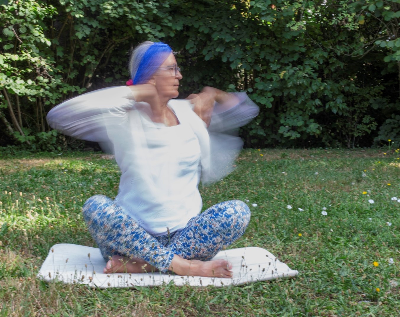 Pratiquante de Yoga Kundalini réalisant un exercice de respiration et de mouvements des bras en plein air pour favoriser l'énergie et le bien-être.