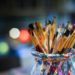 Pinceaux de peinture dans un pot coloré, prêts pour un atelier d'aquarelle ou une activité artistique créative.