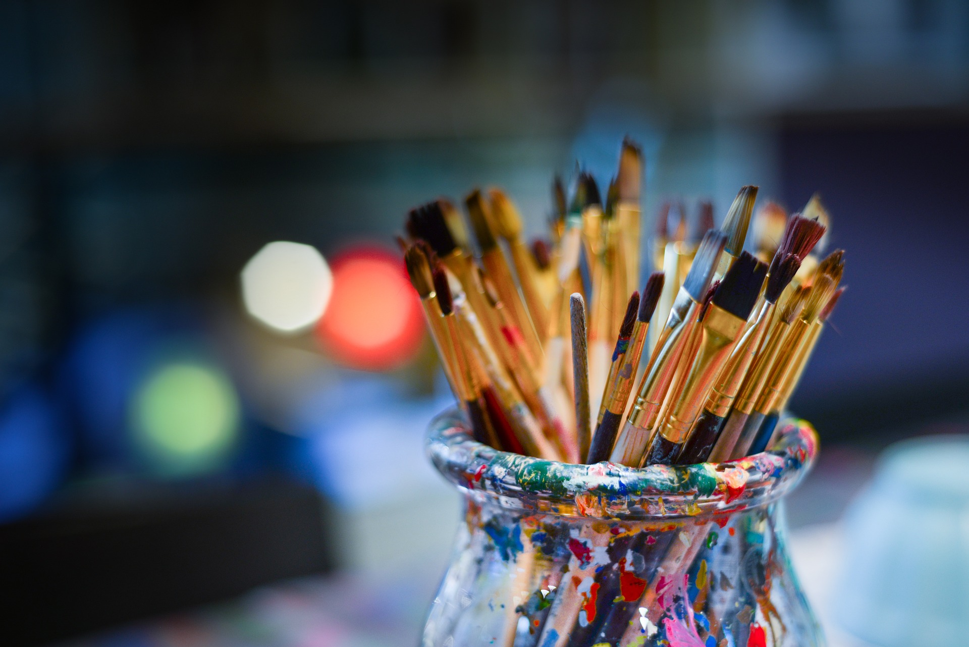 Pinceaux de peinture dans un pot coloré, prêts pour un atelier d'aquarelle ou une activité artistique créative.