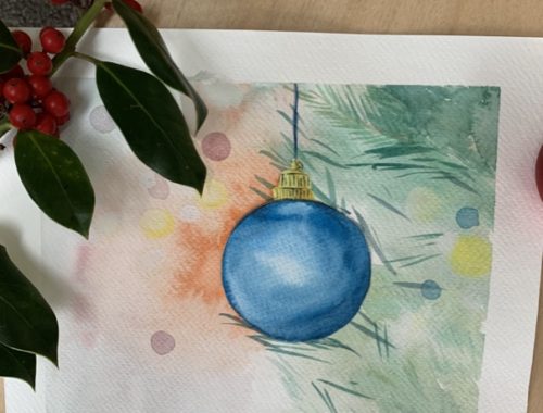 Aquarelle représentant une boule de Noël bleue suspendue à une branche de sapin, réalisée lors d'un atelier de peinture à l'aquarelle.