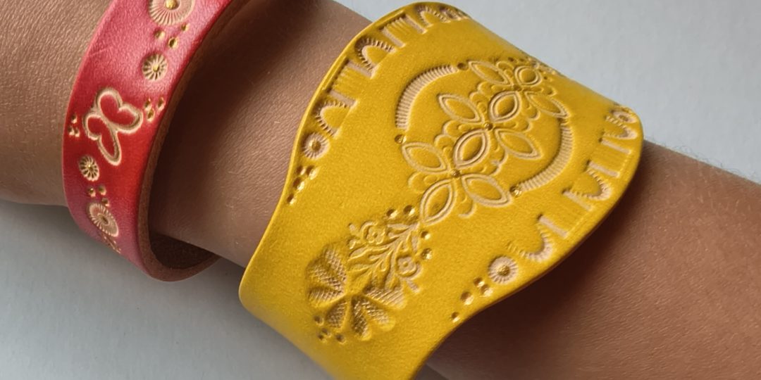 Bracelets en cuir artisanaux décorés de motifs embossés, réalisés lors d'un atelier créatif de maroquinerie.