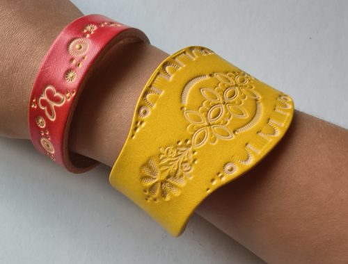 Bracelets en cuir artisanaux décorés de motifs embossés, réalisés lors d'un atelier créatif de maroquinerie.