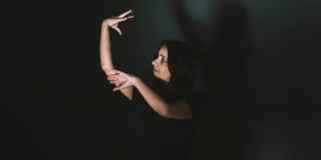 Personne interprétant une chanson en langue des signes française (LSF) lors d'un atelier de chansigne, mêlant musique, expression corporelle et émotion.