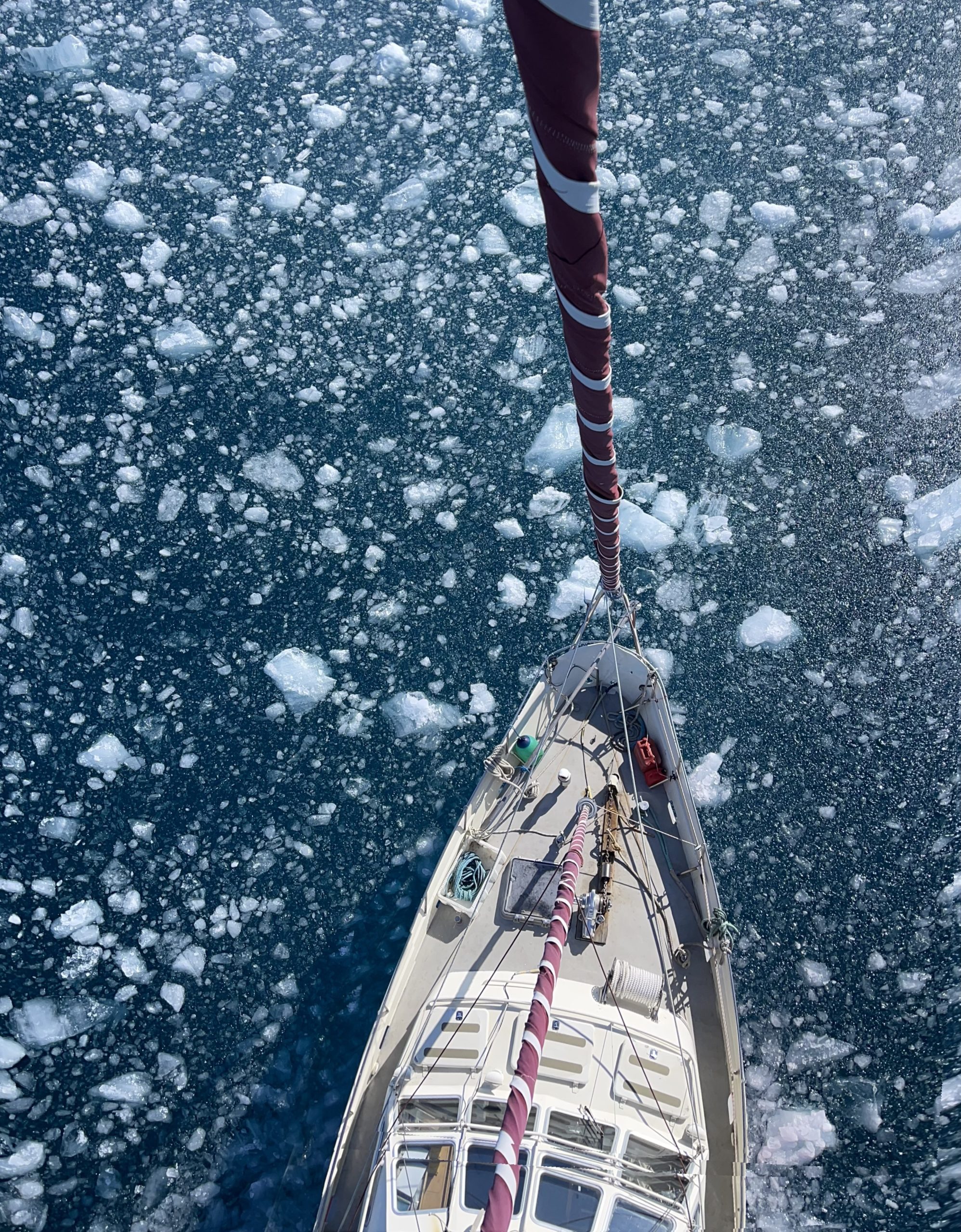 Photo prise d'en haut d'un voilier dans de l'eau glacée.