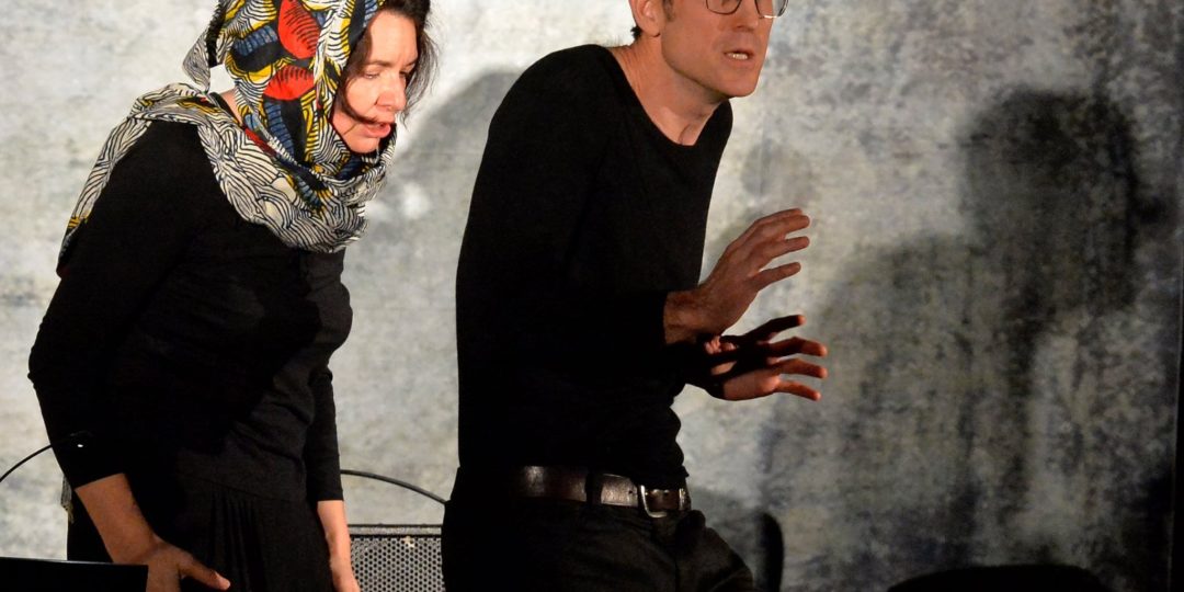 Deux personnes jouant leur rôle de comédiens durant un spectacle.