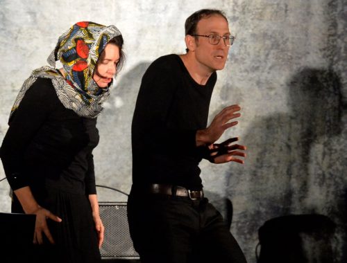 Deux personnes jouant leur rôle de comédiens durant un spectacle.