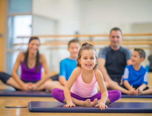 Atelier parent & bambin montrant au premier plan un enfant en tailleur accompagné de sa famille au loin.
