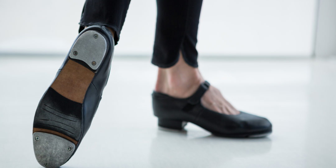 Gros plan sur un danseur portant des chaussures de claquettes en studio
