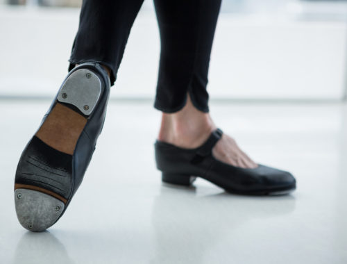 Gros plan sur un danseur portant des chaussures de claquettes en studio