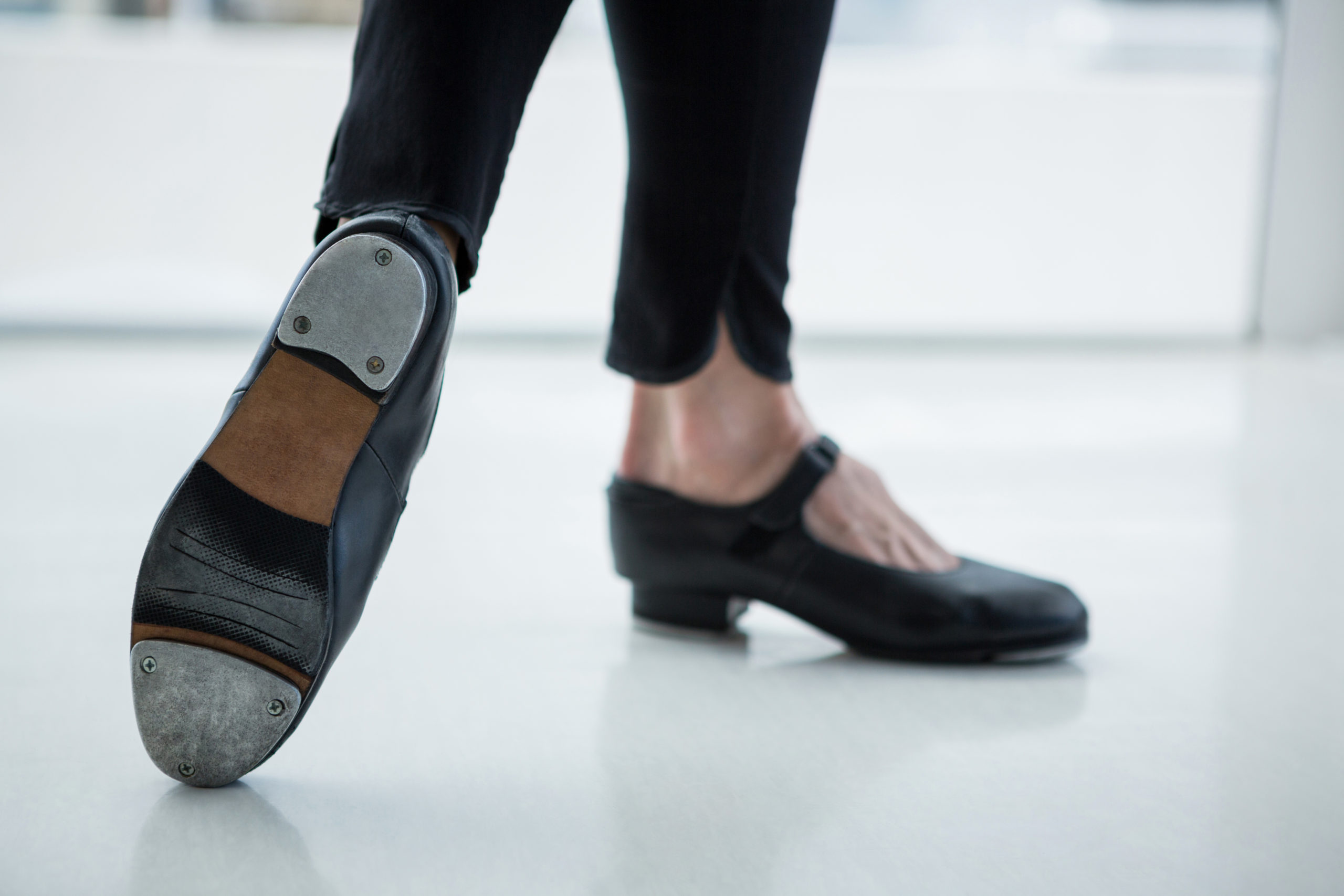 Gros plan sur un danseur portant des chaussures de claquettes en studio