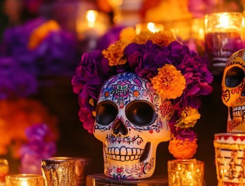 Décoration traditionnelle du Día de los Muertos avec crânes colorés, bougies et fleurs pour un apéro partagé convivial autour de la culture mexicaine.