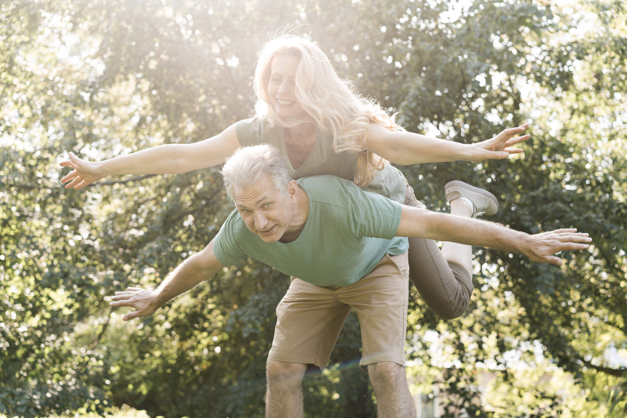 Couple de seniors s'amusant dans un parc, illustrant une conférence sur le vieillissement actif, la santé et le bien-être des seniors.