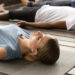 Participants allongés sur des tapis de sol durant une séance de sophrologie consacrée à la relaxation profonde et au bien-être pendant la saison hivernale.