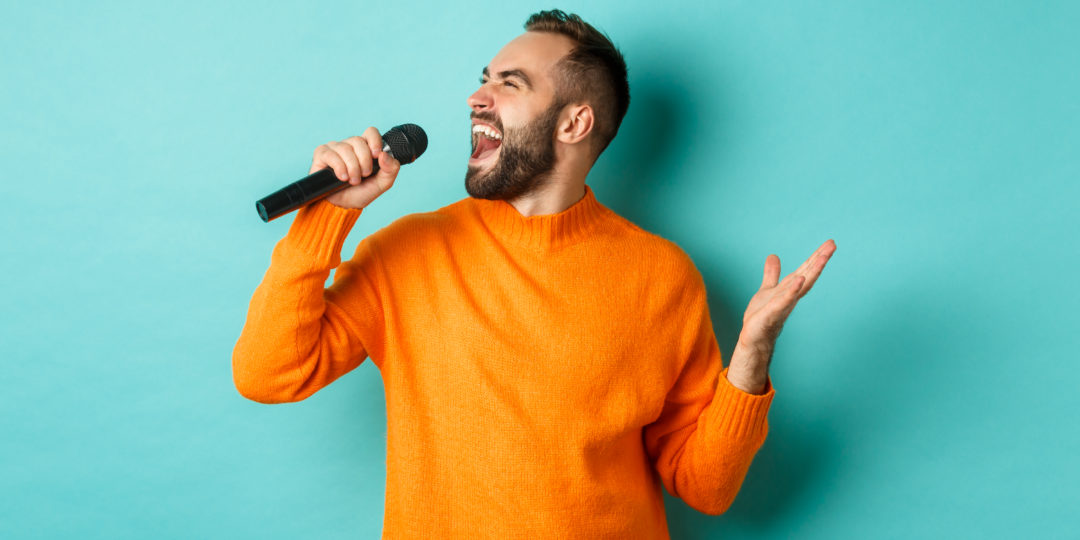 Personne chantant avec un microphone lors d'un atelier de technique vocale pour développer sa voix, sa respiration et son interprétation.
