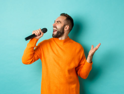 Personne chantant avec un microphone lors d'un atelier de technique vocale pour développer sa voix, sa respiration et son interprétation.