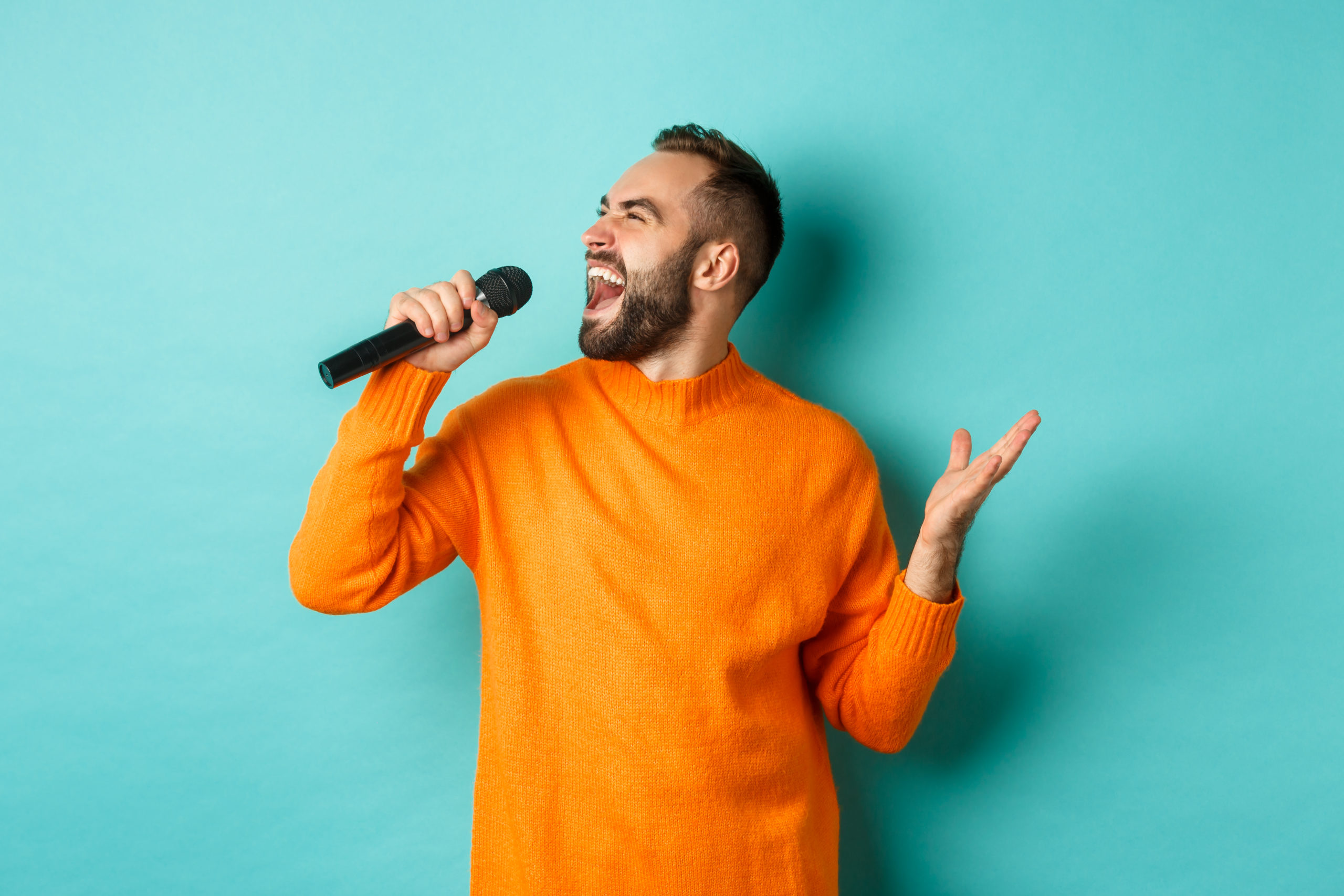 Personne chantant avec un microphone lors d'un atelier de technique vocale pour développer sa voix, sa respiration et son interprétation.