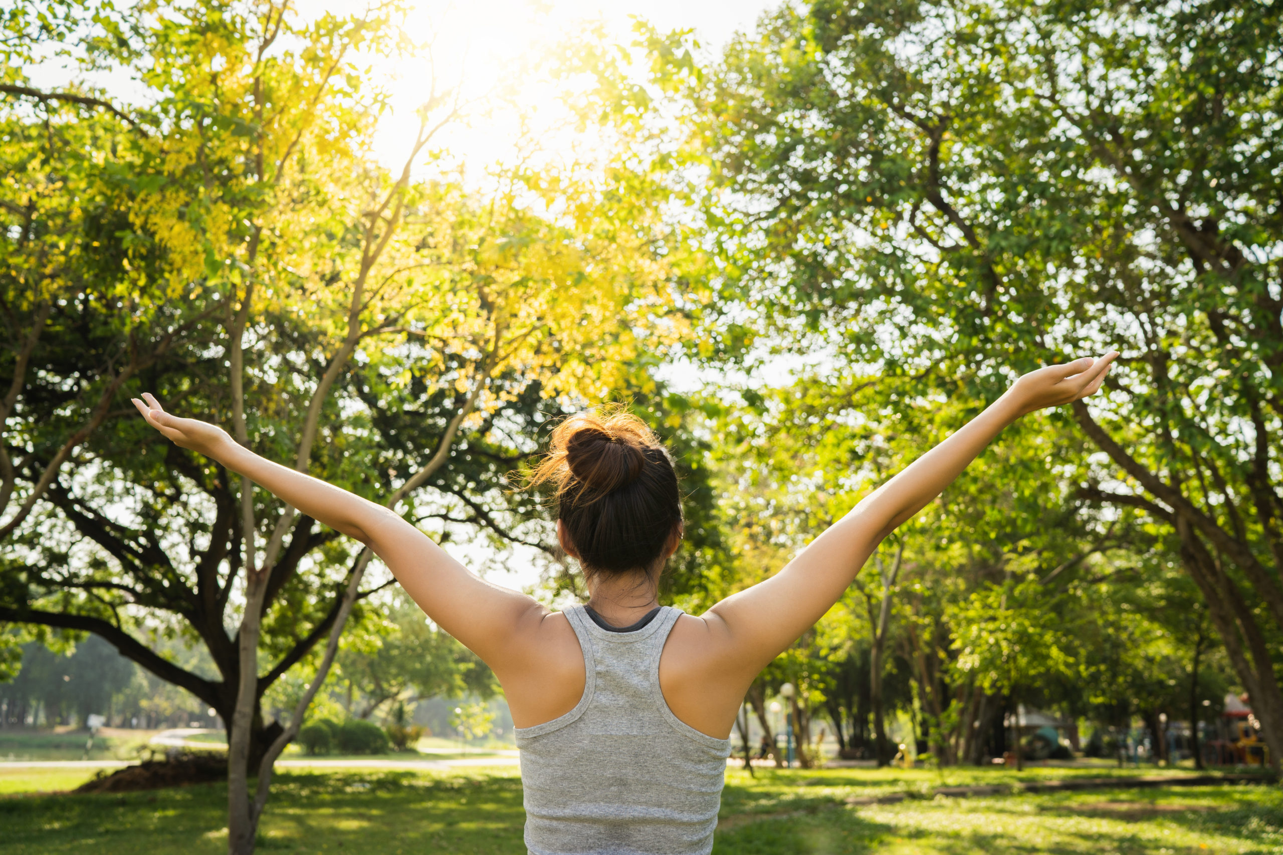 Personne s'étirant en pleine nature pour prendre soin de soi, favoriser le bien-être physique et mental et profiter d'un moment de détente.