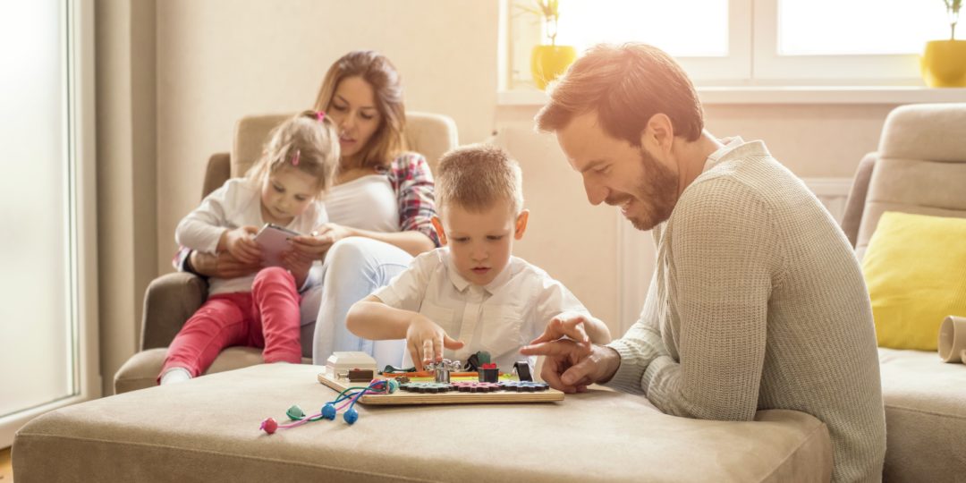 Famille participant à une activité ludique à la maison, favorisant le partage, la créativité et les moments de complicité entre parents et enfants.