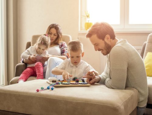 Famille participant à une activité ludique à la maison, favorisant le partage, la créativité et les moments de complicité entre parents et enfants.