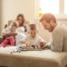 Famille participant à une activité ludique à la maison, favorisant le partage, la créativité et les moments de complicité entre parents et enfants.