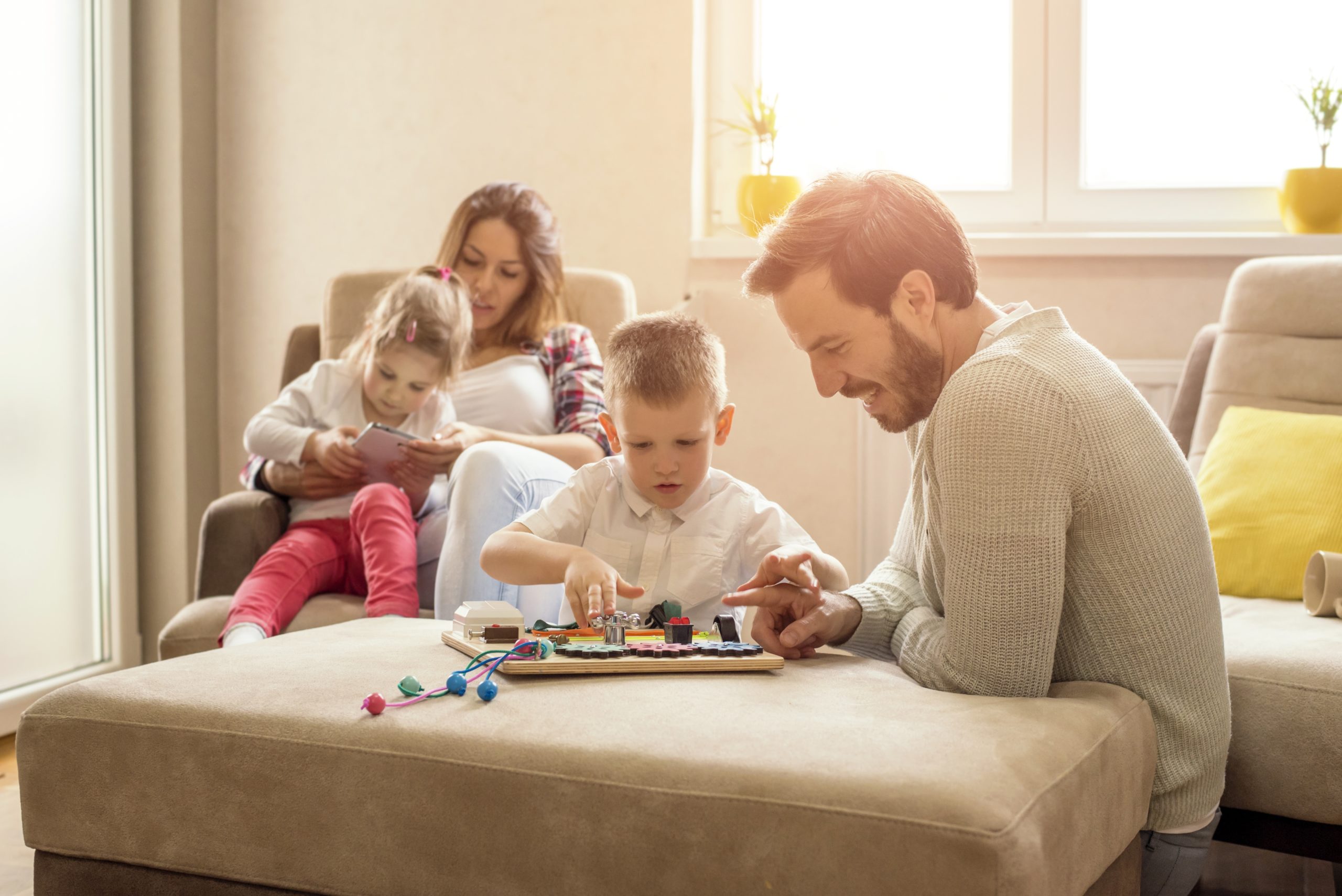 Famille participant à une activité ludique à la maison, favorisant le partage, la créativité et les moments de complicité entre parents et enfants.