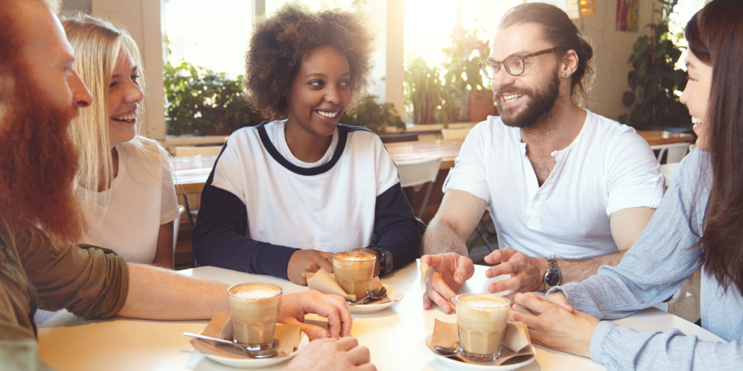 Groupe de personnes échangeant autour d'un café dans un espace convivial, favorisant le bien-être, le partage et les échanges.