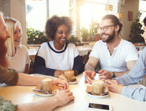 Groupe de personnes échangeant autour d'un café dans un espace convivial, favorisant le bien-être, le partage et les échanges.